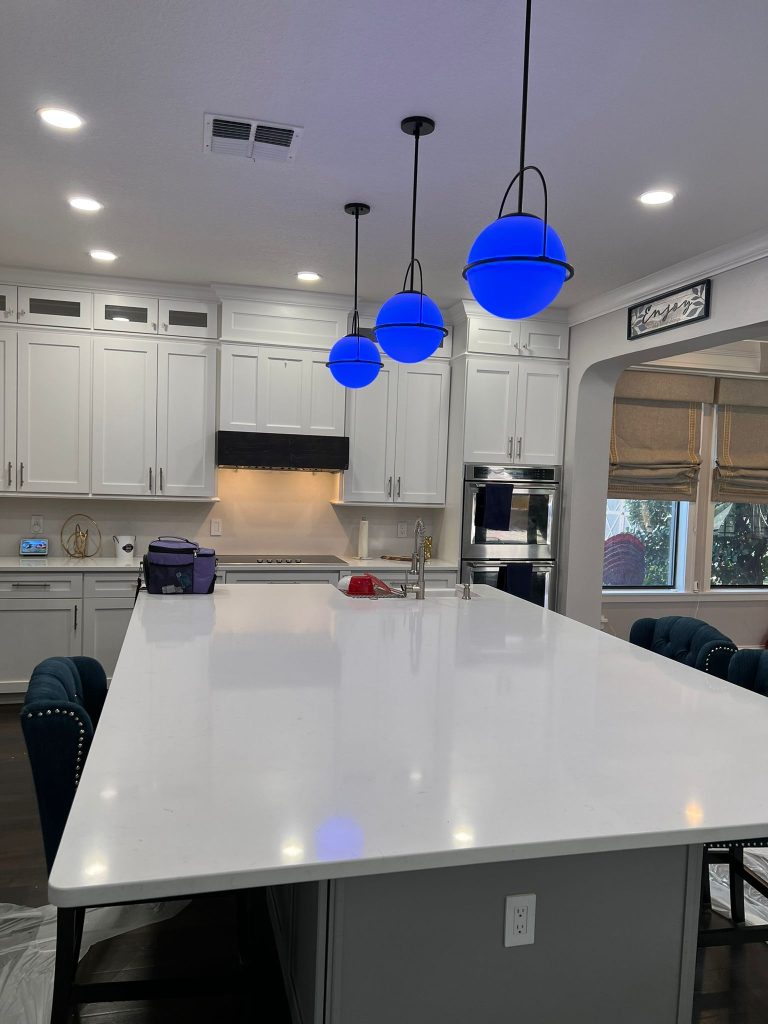 White and gray Orlando kitchen remodel with spacious island, updated cabinetry, modern lighting, and durable flooring